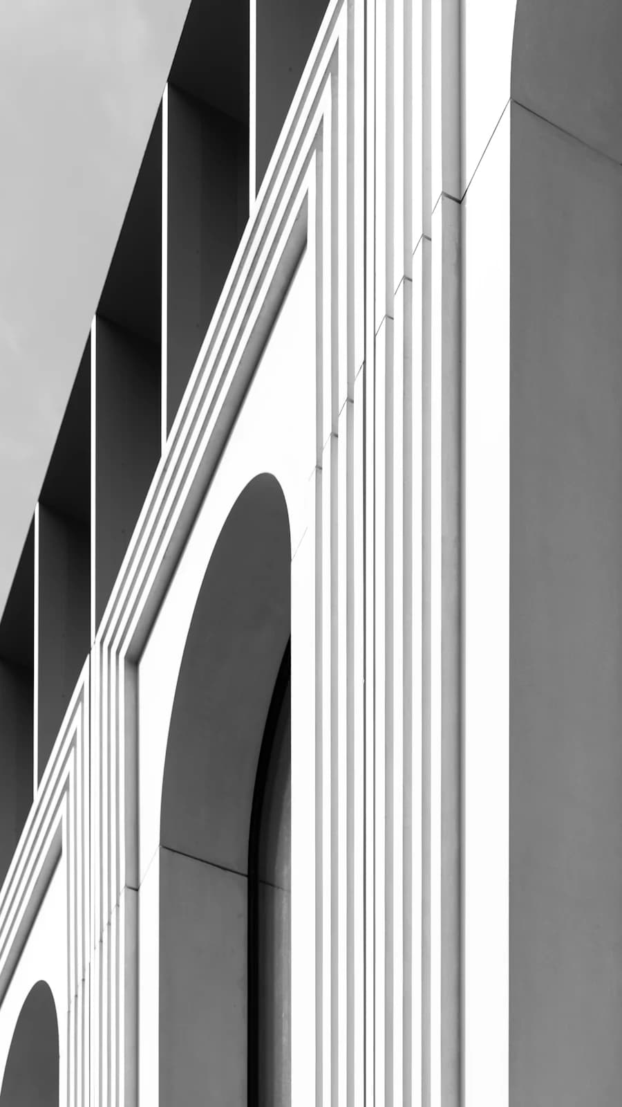 A ribbed white facade cut with tall arched openings