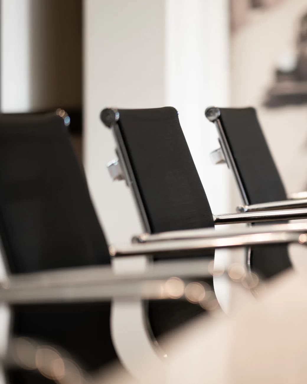 Black leather chairs in a row along a conference table