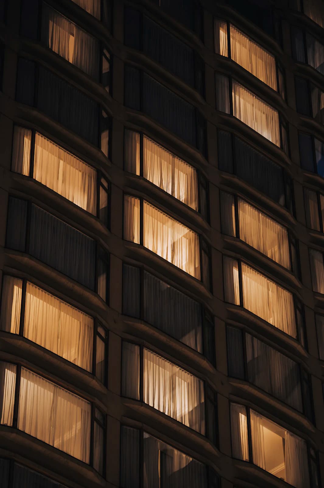 Lit windows across a dark modern facade at night